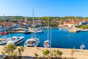 A marina with boats docked, a town in the background, and a prominent church tower. - Sun-Kissed Sailing Adventure in Split-Dalmacia, Croatia (Jesenice)