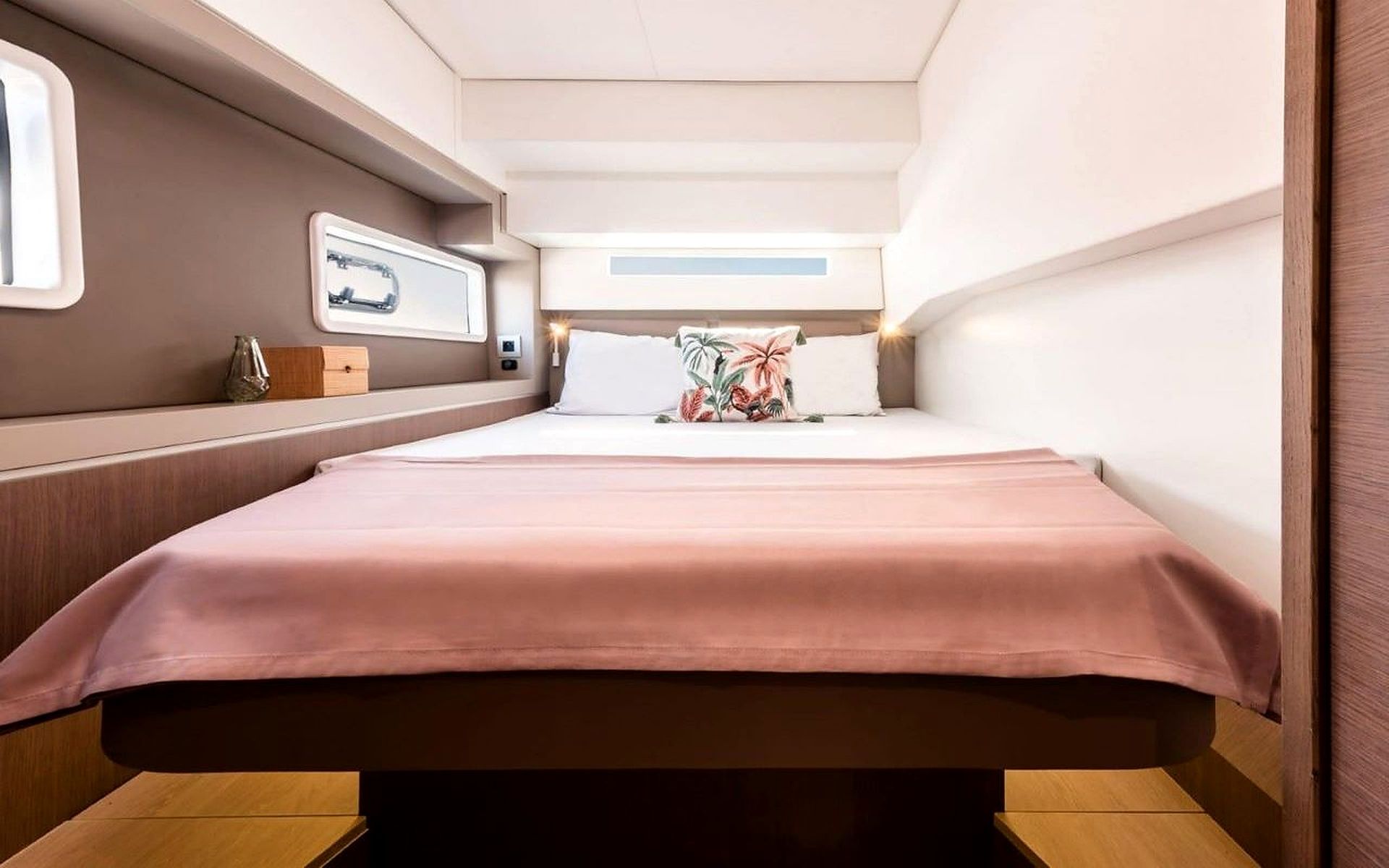 A hotel room with a bed, a nightstand, a window, and a wall-mounted control panel.