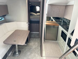 A compact RV interior with a kitchenette, a dining area, and a sleeping space. - Sun-kissed Sailing Adventure in Split-Dalmatia, Croatia (Seget Donji)