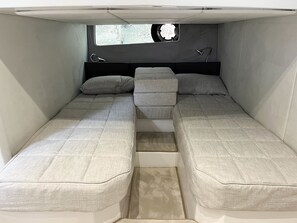 A compact RV interior with two beds, a small window, and a headboard. - Sun-kissed Sailing Adventure in Split-Dalmatia, Croatia (Seget Donji)