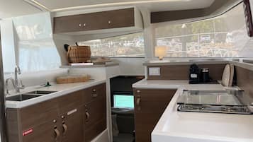 Una cocina compacta con fregadero, estufa y alacenas.
