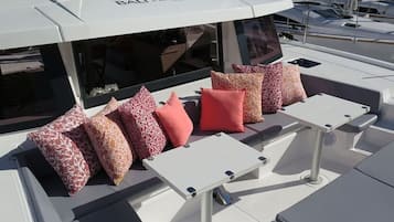 A boat deck with seating areas, a canopy, and a visible logo.