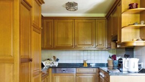 Una cocina con armarios de madera, lavavajillas y cafetera.