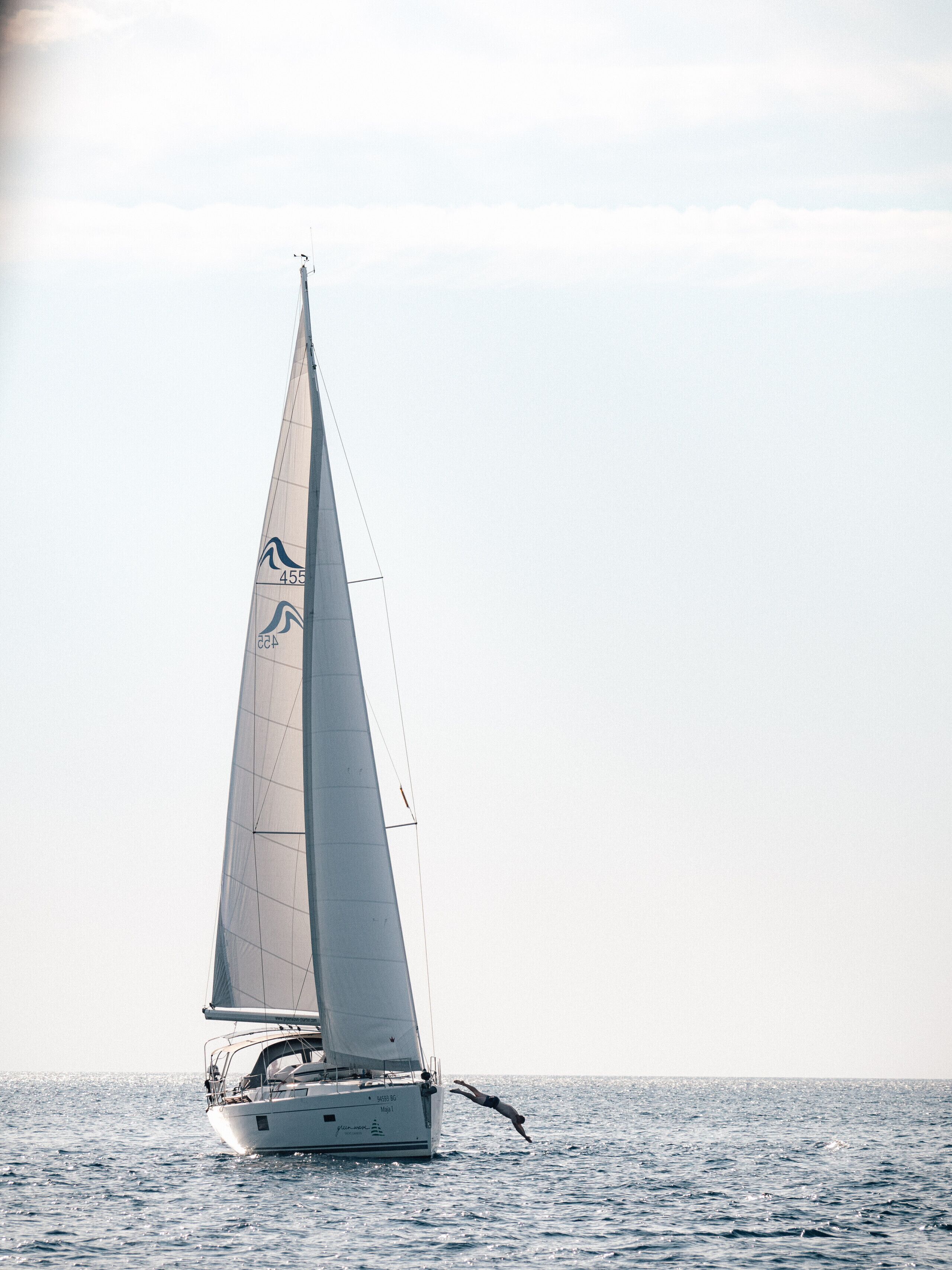 A sailboat with a large sail on the water.