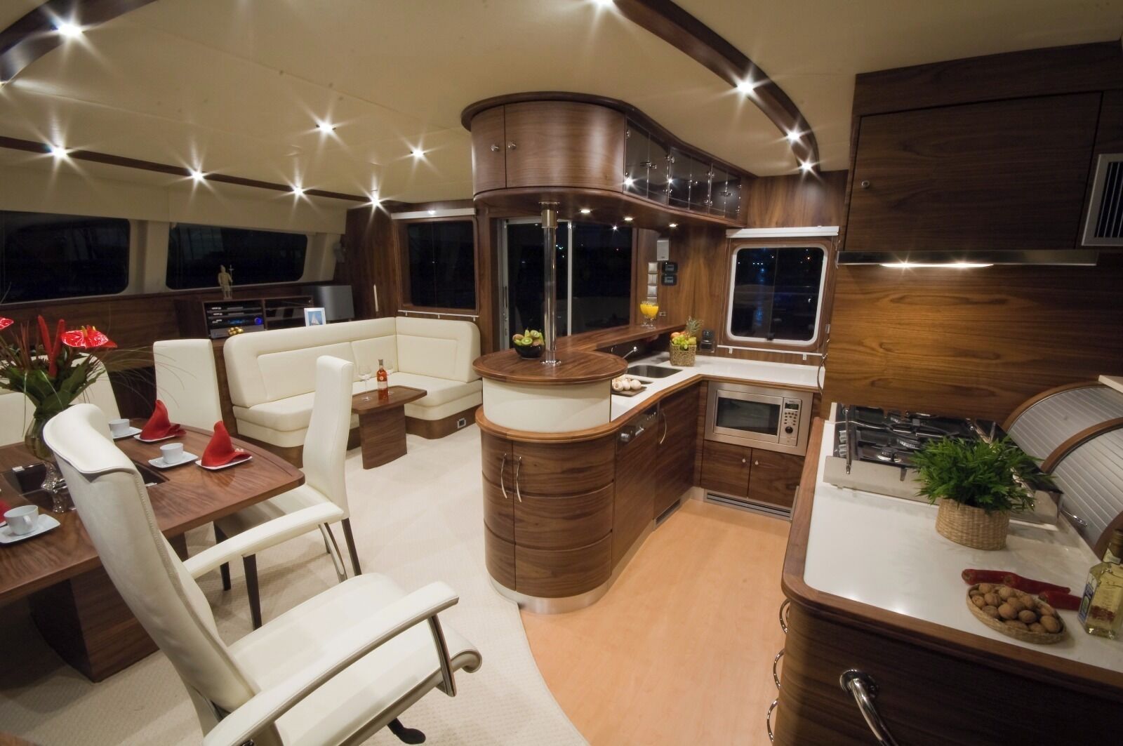 Un interior acogedor y bien iluminado con comedor, asientos, cocina y un ventanal grande.