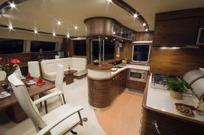 A compact, well-lit interior with a dining area, seating, a kitchen, and a large window.