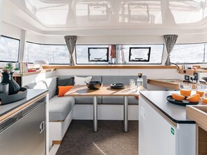 A compact galley with a dining area, kitchenette, and seating. - Sun-soaked Sailing Adventure in the Ionian Islands (Perigiali)