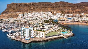 A coastal town with a marina, white buildings, and a hill in the background. - Sun-Kissed Sailing Adventure in Gran Canaria, Islas Canarias (Las Palmas de Gran Canaria)