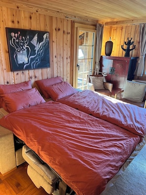 Een kamer met houten lambrisering, een groot bed, een stoel en een kast.