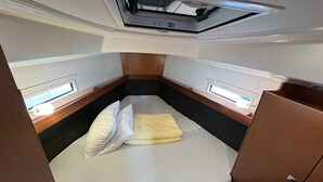 A compact, well-lit cabin with a single bed, a small window, and a ceiling vent. - Sun-Kissed Sailing Adventure in Northern Croatia (Punat)