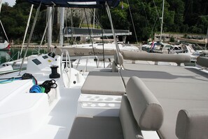 Ein Bootsdeck mit Sitzgelegenheiten, einem Steuerbord und einem Mast.