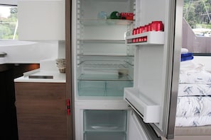 A modern kitchen with a built-in refrigerator, a wooden countertop, and a window with a view of greenery. - Dubrovnik Delight: A Sun-Kissed Sailing Experience (Komolac)