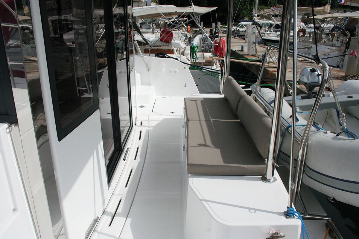 A boat deck with seating, a window, and various nautical equipment.