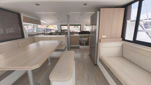 Ein modernes Interieur mit Essbereich, einer Bank, einer Couch und einer Küchenzeile.