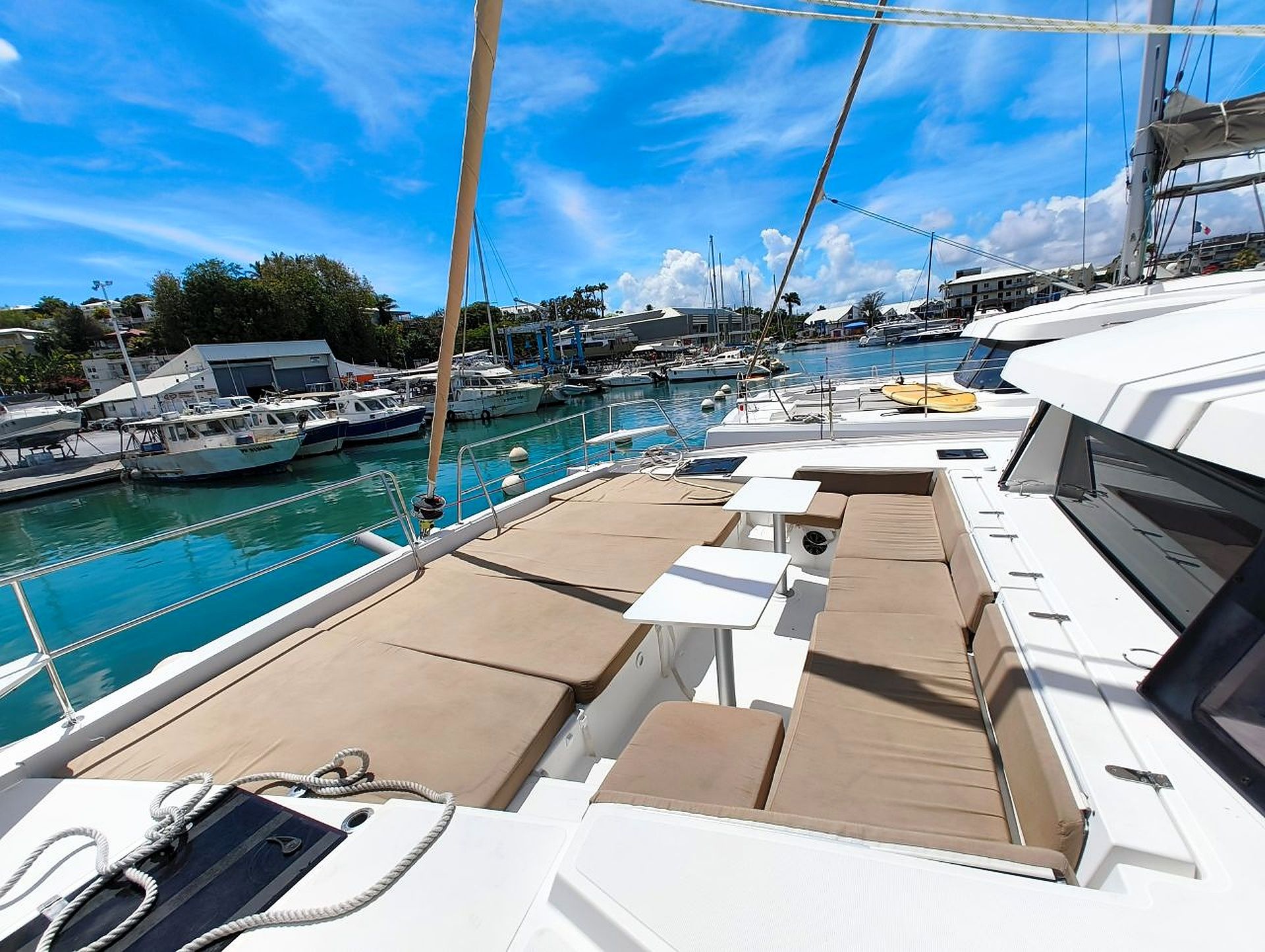 A marina with boats docked, a clear sky, and a view of the marina's buildings.
