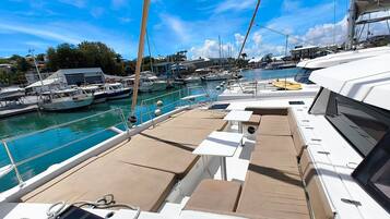 A marina with boats docked, a clear sky, and a view of the marina's buildings.
