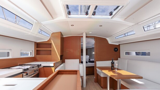 Una cocina compacta con estufa, pileta y zona de estar, con tragaluces y vista al deck.