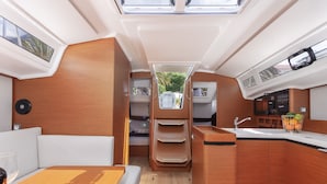 Un interior compacto con kitchenette, zona de estar y un ventanal pequeño.