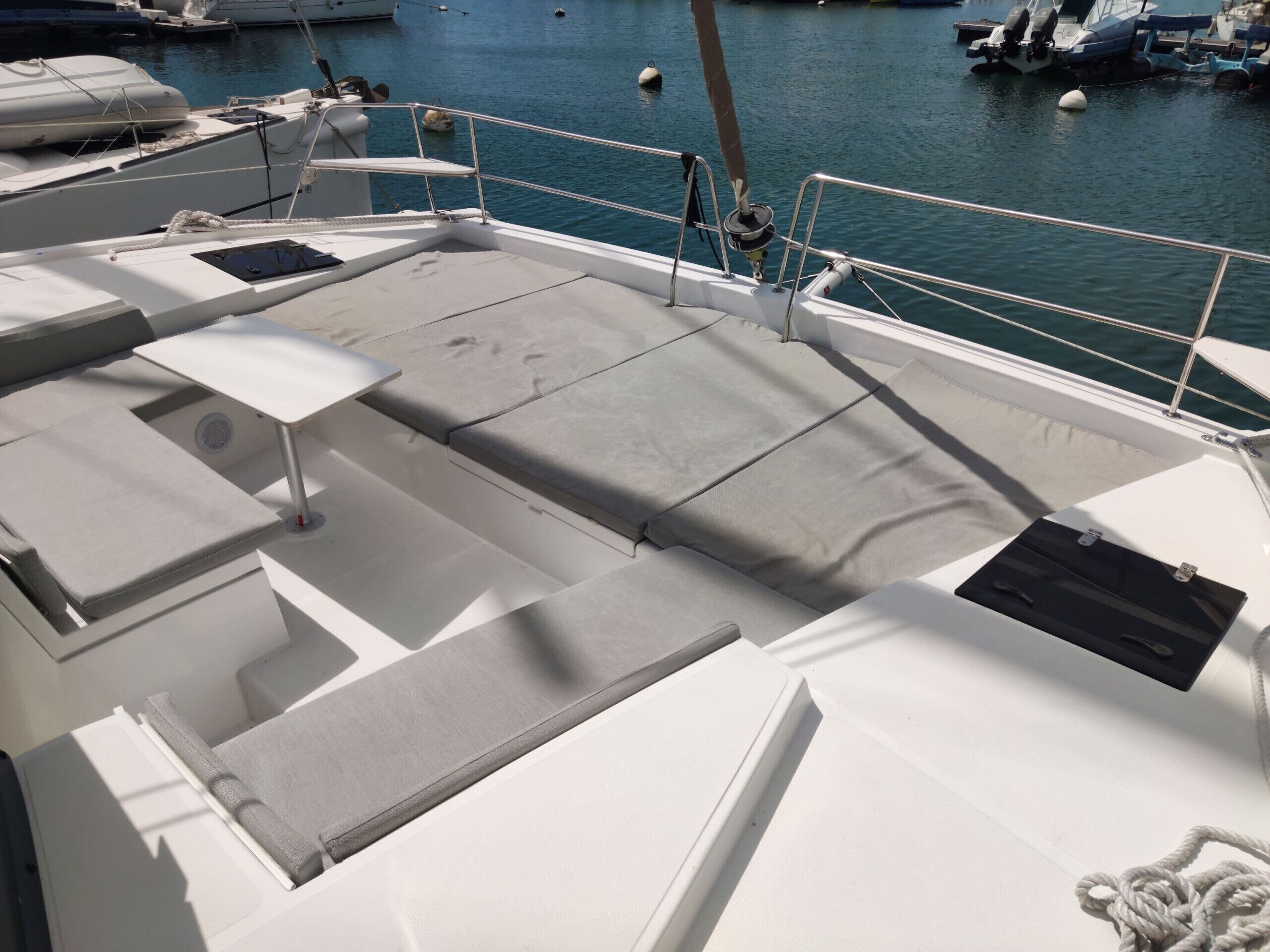 Ein Bootsdeck mit Sitzbereichen, einem Tisch und einem kleinen Tisch mit Abdeckung.
