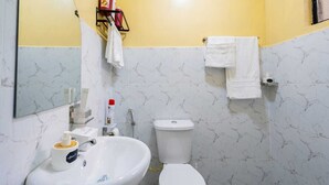 A bathroom with a sink, toilet, and a mirror. - Cozy, secure home stay with modern comforts and a convenient location. (Kisii County)