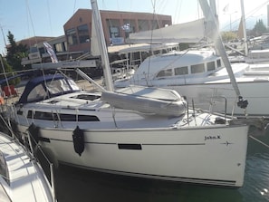 En småbåtshamn med flera segelbåtar förtöjda, varav en heter ”John.K”.