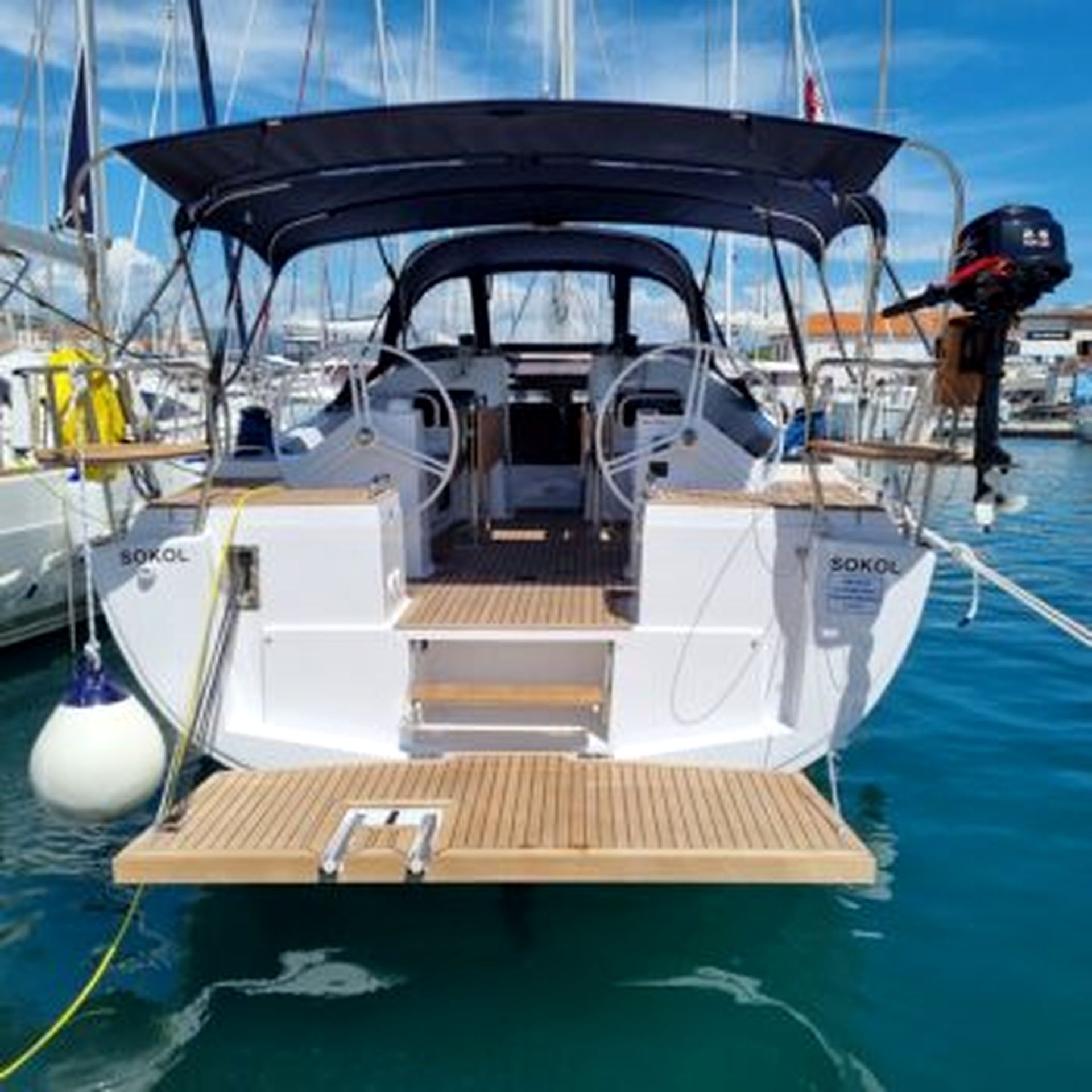 A sailboat with a covered deck, a steering wheel, and a winch.