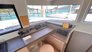 Een kleine keuken met een spoelbak, fornuis en uitzicht op een jachthaven.
