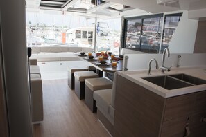 A compact kitchen with a sink, dining area, and seating. - Sun-kissed Sailing Adventure in the Ionian Islands (Preveza)