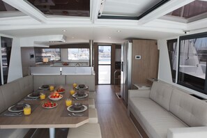 A modern interior with a dining area, kitchen, and seating. - Sun-kissed Sailing Adventure in the Ionian Islands (Preveza)