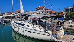 A marina with a sailboat docked, surrounded by buildings and other boats. - Sun-Kissed Sailing Adventure in the Ionian Islands, Lefkada (Lefkada)