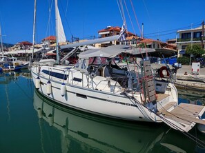 Ein Yachthafen mit einer Segelyacht, umgeben von Gebäuden und weiteren Booten.