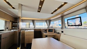 Una cocina moderna con una isla central, electrodomésticos integrados y grandes ventanales con vistas al puerto deportivo.