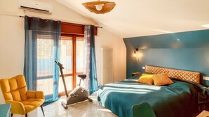 Ein Schlafzimmer mit einem Bett, einem Ergometer und einem Sessel.