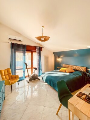 A bedroom with a bed, exercise bike, and a chair. - The Sabi Terraces (Giulianova)