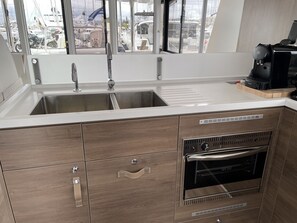 Eine moderne Küche mit einem Doppelwaschbecken, Holzschränken und einem Backofen.
