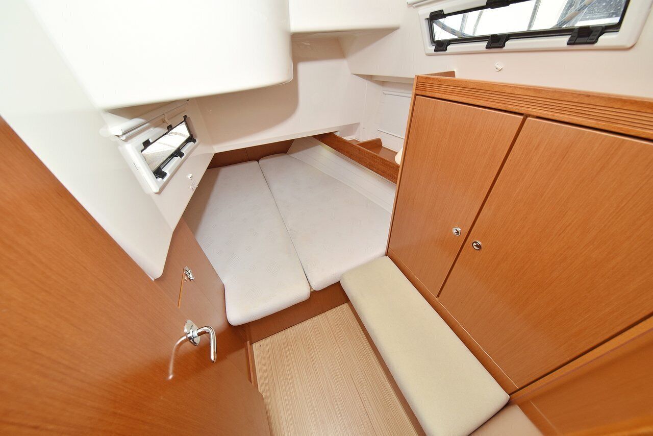 A compact cabin with a bench, storage cabinets, and a small window.