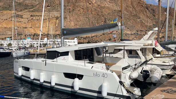 En småbåtshamn med förtöjda båtar, bland annat en vit yacht som heter ”Isla 40”.
