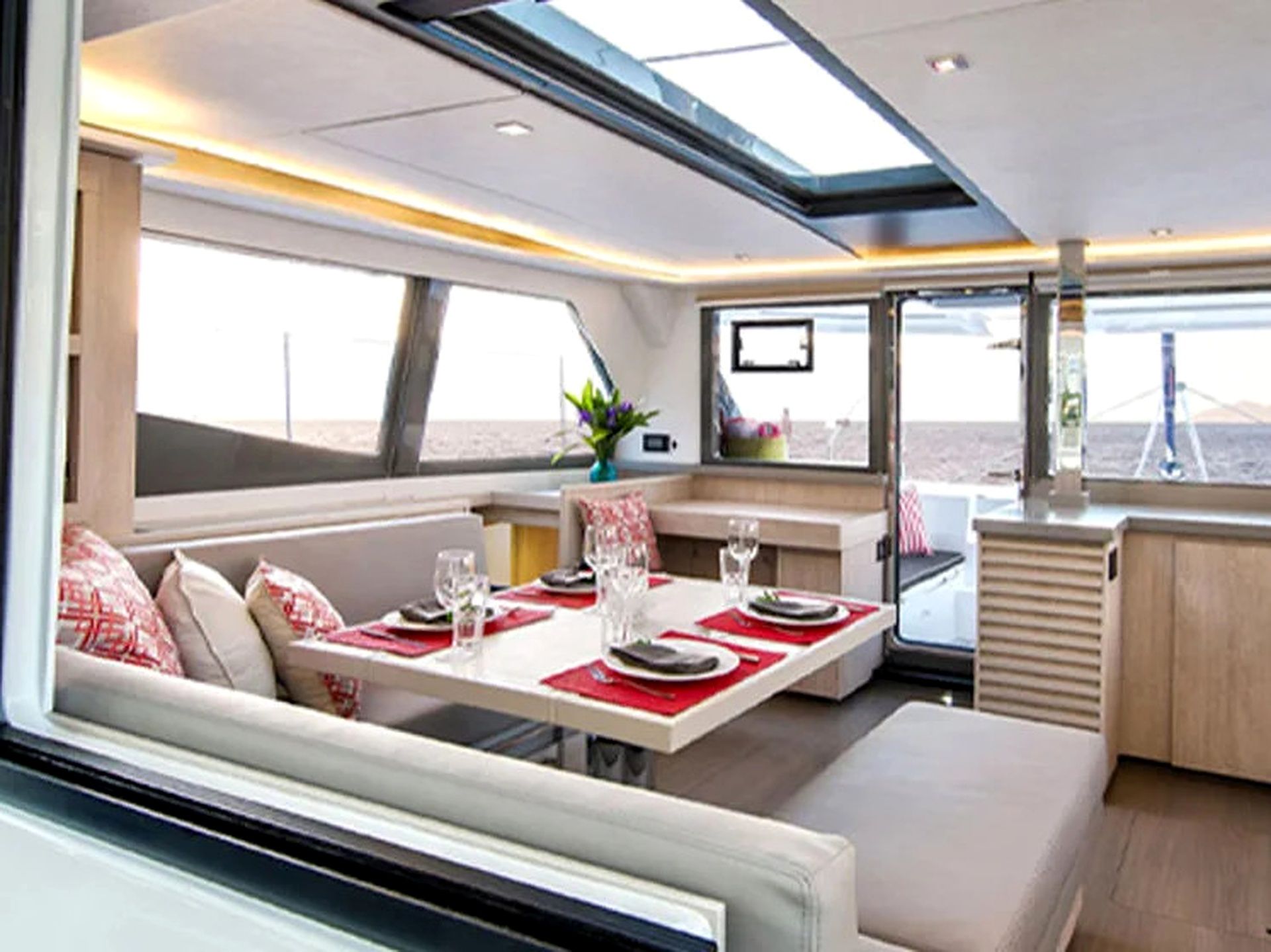 A dining area with a table set for two, a sofa, and a window with a view.