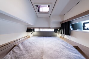 A compact, well-lit room with a skylight, a bed with a headboard, and a window with curtains. - Sun-Kissed Sailing Adventure in the Ionian Islands, Lefkada (Lefkada)
