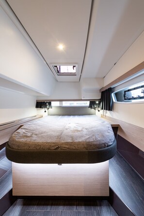 Ein modernes, helles Interieur mit einem großen Bett, einem Oberlicht und einem Fenster für natürliches Licht.