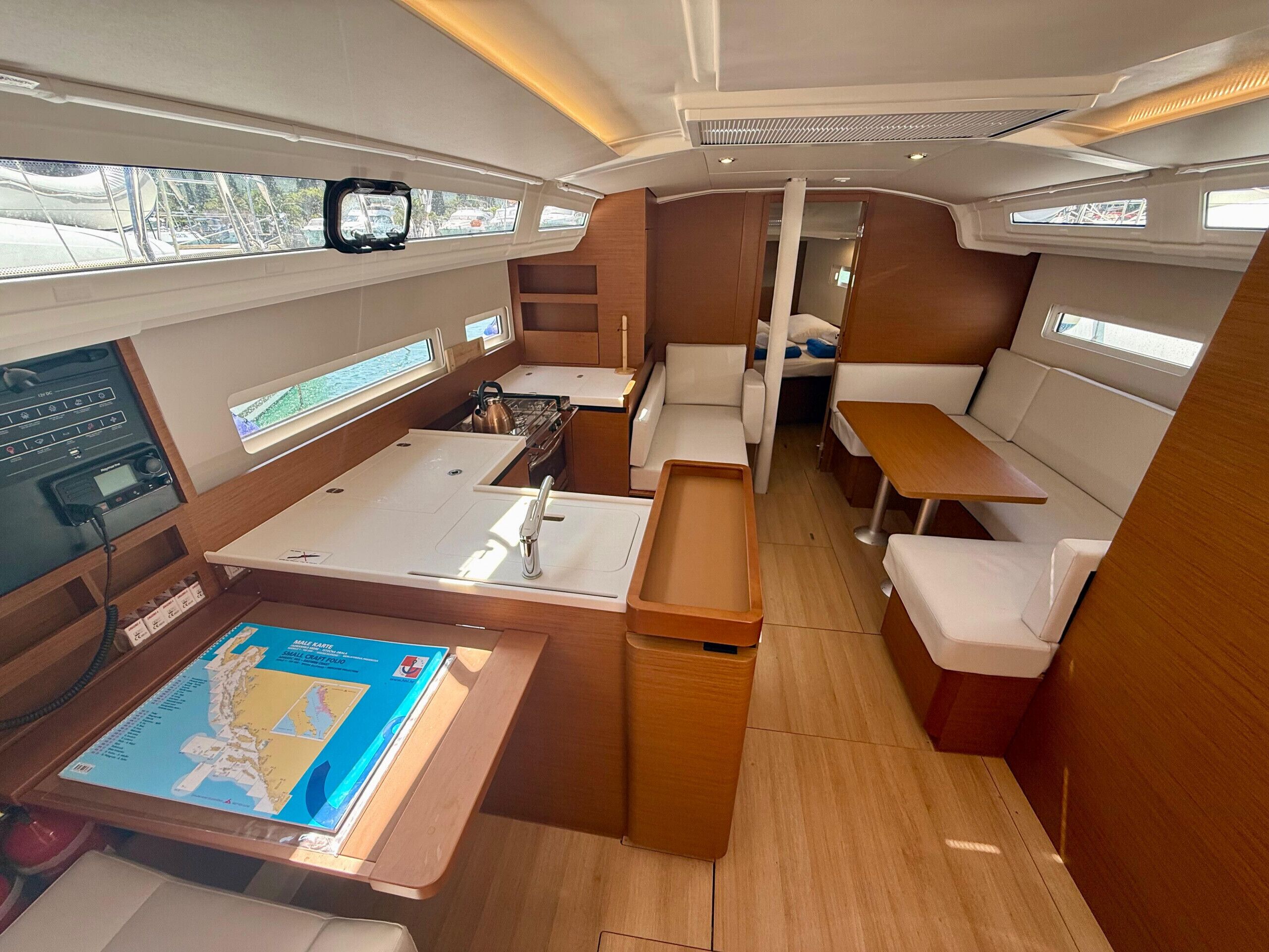 A compact interior with a kitchenette, seating area, and a control panel.