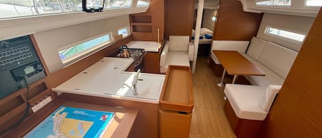A compact interior with a kitchenette, seating area, and a control panel.