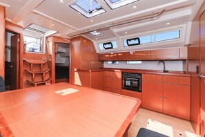 A compact kitchen with a dining table, built-in oven, and a window above the sink. - Sun-Kissed Sailing Adventure in Zadar, Croatia (Zadar)