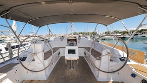 A boat deck with a steering wheel, a small table, and a canopy overhead. - Sun-Kissed Sailing Adventure in Zadar, Croatia (Zadar)