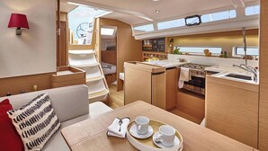 A compact galley with a dining area, a sink, and a stove. - Sun-Kissed Sailing Adventure in Northern Croatia (Punat)