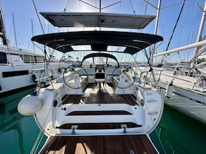 Ein Bootsdeck mit Steuer, Verdeck und dem Namen 'Zoilo' an der Seite.