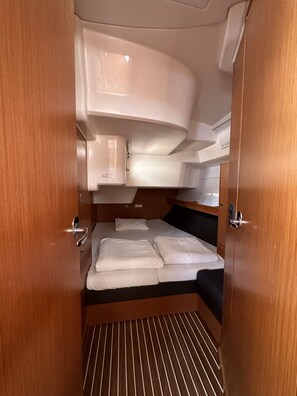A compact interior with a bunk bed, a small kitchenette, and a door with a handle. - Sun-Kissed Sailing Adventure in Zadar, Croatia (Bibinje)