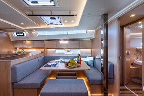 A modern interior with a dining area, seating, and a kitchen. - Sun-Kissed Sailing Adventure in the Ionian Islands, Lefkada (Lefkada)