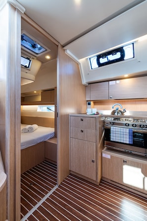 A compact kitchen with a stove, oven, and a small window above the sink. - Sun-Kissed Sailing Adventure in the Ionian Islands, Lefkada (Lefkada)