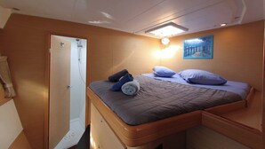 Een slaapkamer met een bed, douche, schilderij en een lamp.
